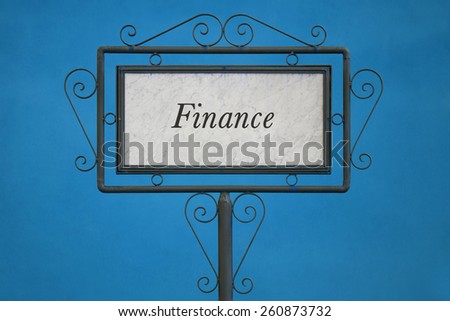 The Word "Finance" on a Signboard. Light Blue Background.