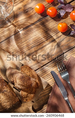 Top view of empty wineglass with bread on served wooden table