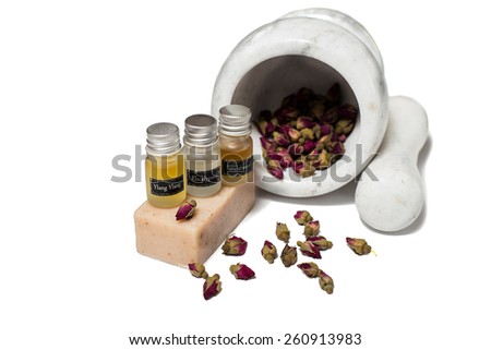 Marble pounder with bottles of organic oils, roses and soap isolated