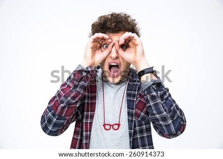 Surprised young man looking through fingers