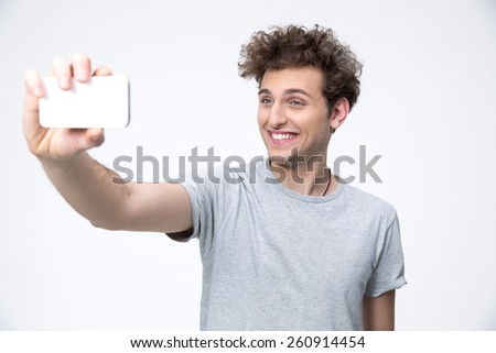 Smiling casual man making photo on smartphone