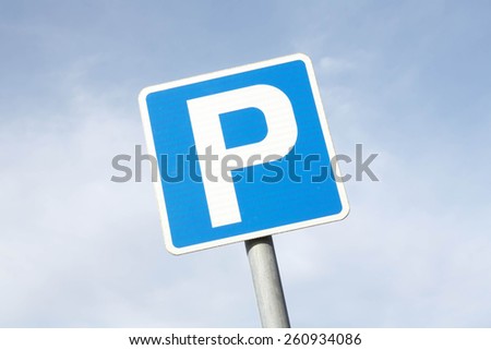 Isolated Parking Sign - Blue road sign with letter P on rectangular plate isolated against a blue sky.