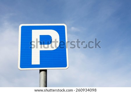 Isolated Parking Sign - Blue road sign with letter P on rectangular plate isolated against a blue sky.