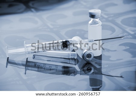 Glass Medicine Vials with botox, hualuronic, collagen or flu Syringe  (shallow DOF) Royalty-Free Stock Photo #260956757