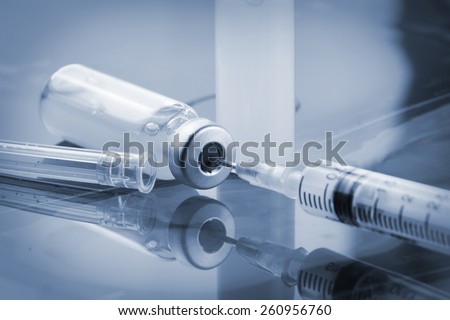 Glass Medicine Vials with botox, hualuronic, collagen or flu Syringe  (shallow DOF) Royalty-Free Stock Photo #260956760