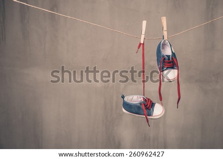 Baby shoes hanging on the clothesline Royalty-Free Stock Photo #260962427