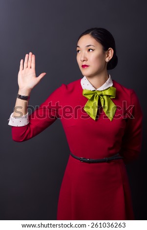 A picture of an attractive Asian stewardess pointing at something