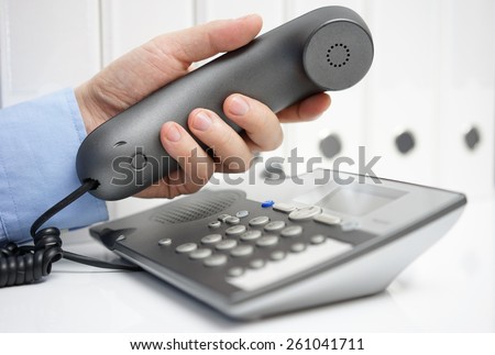adviser is picking up telephone handset, support concept