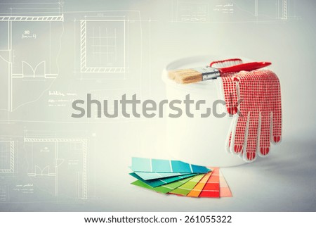 interior design and home renovation concept - paintbrush, paint pot, gloves, pantone samplers and blueprint