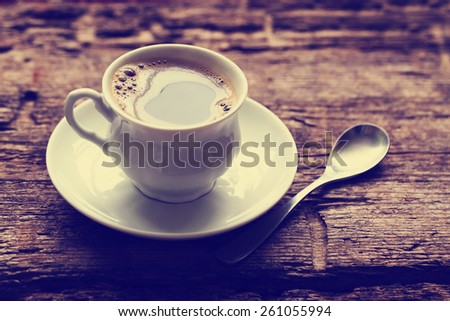 A cup of hot coffee on wooden background/ Romantic background with retro filter effect