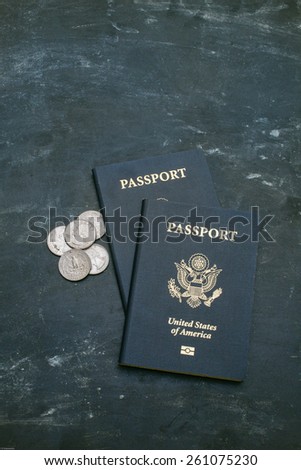 Two US passports on black background. American citizenship. Traveling around the world. Coins on a side