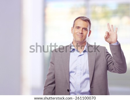 businessman okay gesture  next to a window