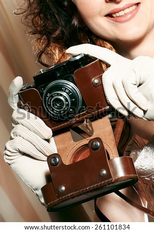 Beautiful young girl in a dress and retro camera in hand