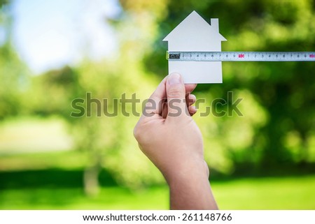 Man's hand holding a cardboard house