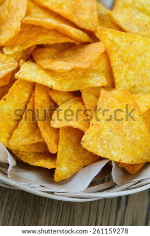 tortilla chips in basket on wooden surface