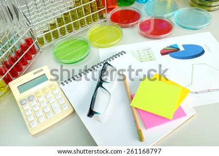 chart and experiment with Colorful fluid in petridish and bottle background on table in laboratory
