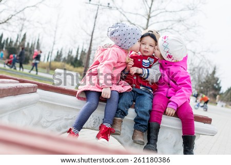 fun toddlers playing in the park sitting on the bench