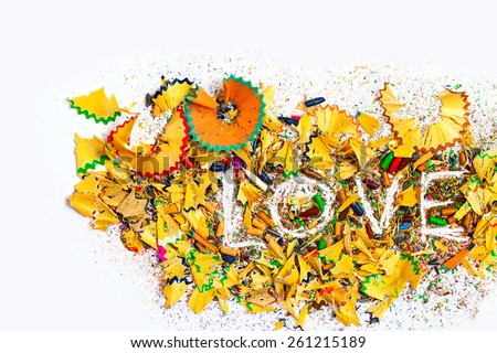 word Love on the white background of colored pencils shavings, still life