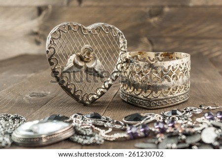 Vintage heart shape jewelry box and jewels on wooden background