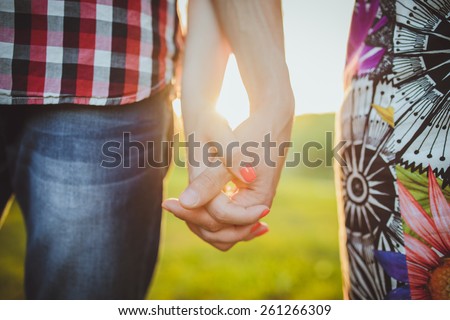 Couple walking holding hands in a park - Romantic date outdoors Royalty-Free Stock Photo #261266309