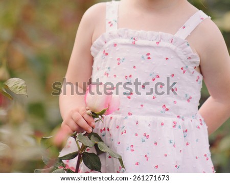 girl holding rose at garden