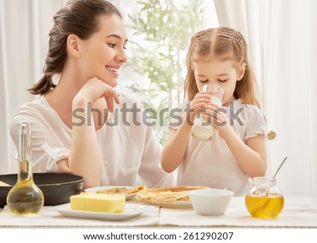girl drinking milk at the kitchen Royalty-Free Stock Photo #261290207