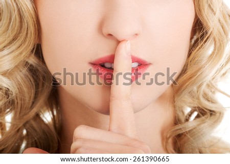 Portrait of a woman making silence gesture.