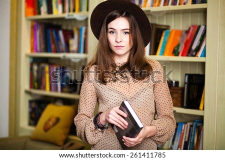 beautiful young girl student near the bookshelves in the library.
Â  concept formation. University, School