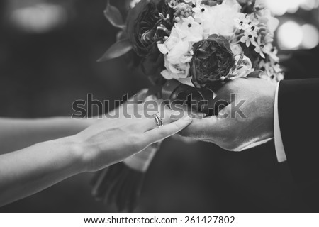 Hands of newlywed couple in love, wedding on summer day.  Picture in black and white. 