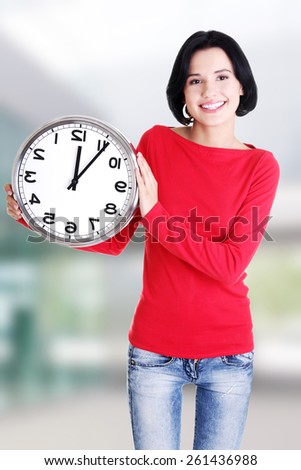 Happy young woman holding office clock.