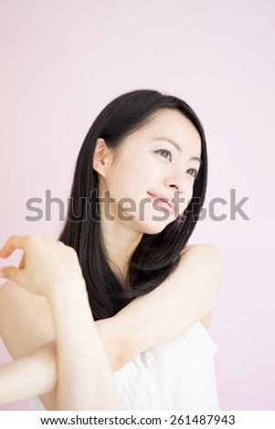 beautiful young woman stretching against pink background