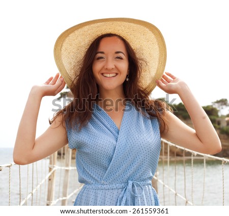 Young woman with summer hat posing on the bridge, happy vacation