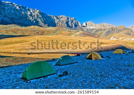Trekking tourists camp in the mountains in the morning. Picture was taken during the hike in scenic Caucasus mountains at autumn, Arhiz region, Abishira-Ahuba range, Karachay-Cherkessia, Russia