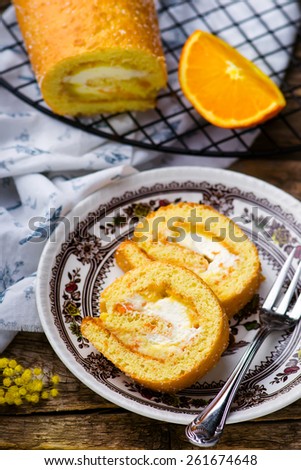 swiss roll with whipped cream and orange cream. style rustic. selective focus