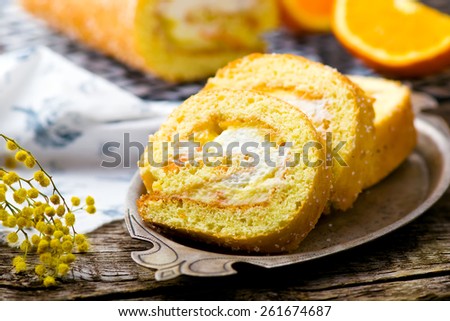 swiss roll with whipped cream and orange cream. style rustic. selective focus