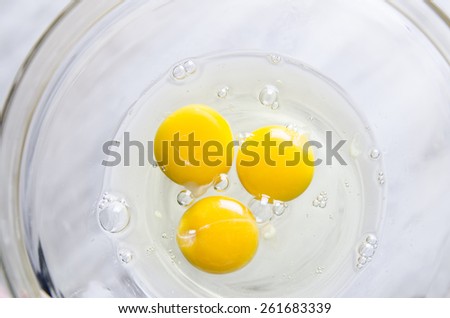 Beautiful picture of eggs in a white bowl with beaters near yolk