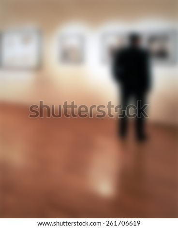 Man at photography exhibition. Intentionally blurred editing post production.