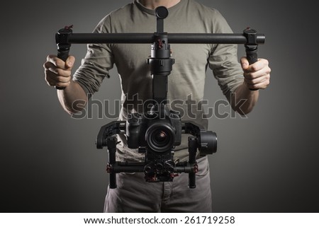 Professional videographer with gimball video slr Royalty-Free Stock Photo #261719258