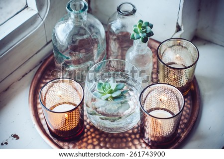 Old bottles, candles on a copper vintage tray, vintage home decor Royalty-Free Stock Photo #261743900