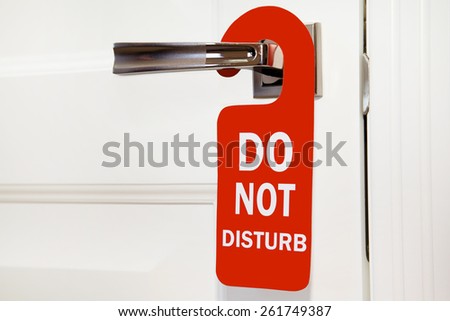 Hotel do not disturb red sign on white door Royalty-Free Stock Photo #261749387