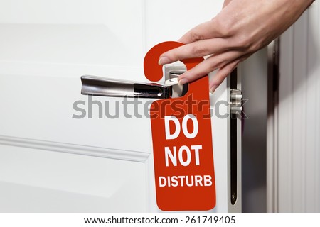 Signboard do not disturb  hanging on open door in a hotel Royalty-Free Stock Photo #261749405