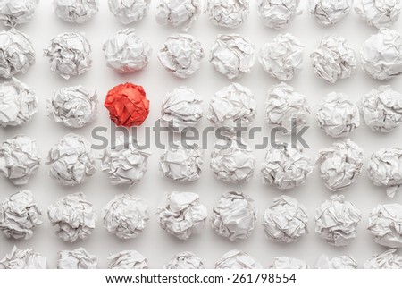overhead shot of crumpled paper in oder and red one standing out. great idea concept on the white office table Royalty-Free Stock Photo #261798554