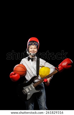 The red-haired boy with a variety of implements on itself on a black background