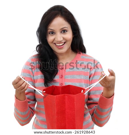 Cheerful woman holding opened shopping bag