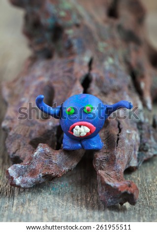 Blue plasticine monster on the wooden background
