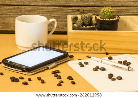 Coffee in a cup with cactus on wooden background