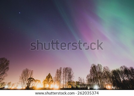 Beautiful landscape panoramic picture of northern lights aurora borealis natural phenomenon over the forest in the night with a church