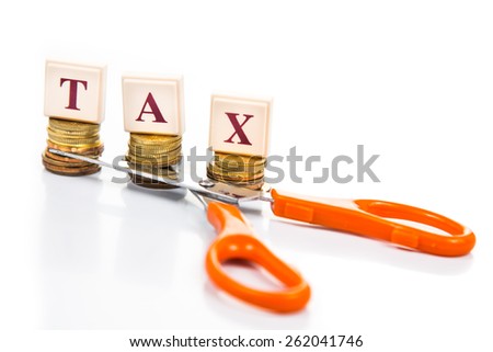 Cut taxes concept with coins, words and scissors Royalty-Free Stock Photo #262041746