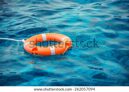 Lifebuoy in a stormy blue sea Royalty-Free Stock Photo #262057094