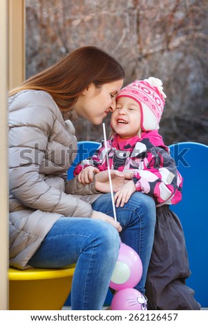mother and daughter in the park in the gazebo in spring day
